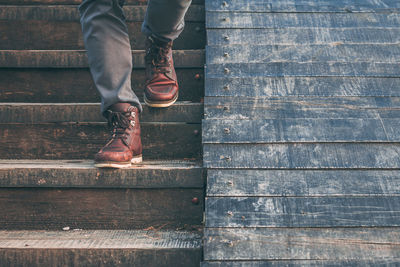 Low section of man standing on wood