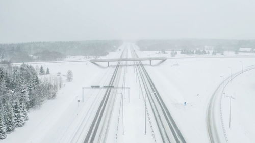 Snow covered railroad tracks against sky