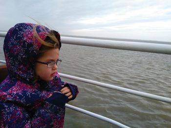 Side view of young girl with glasses on railing