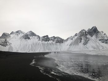 Scenic view of snowcapped mountains by sea against sky