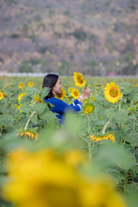 Woman with yellow flowers on field