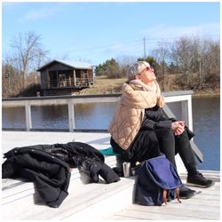 Woman wearing warm clothing sitting outdoors