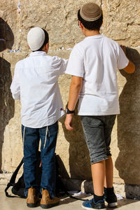 Friends standing against wall