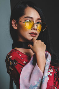 Close-up portrait of young woman wearing sunglasses