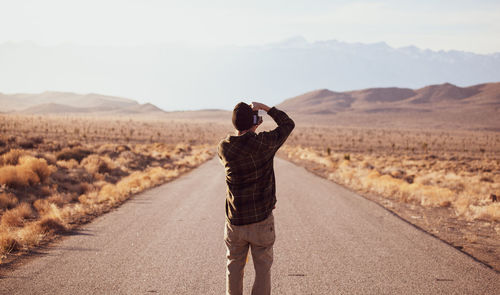 Rear view of man standing on road