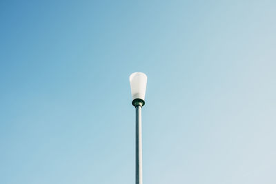 Detail view of broken street lamp without roof against blue sky