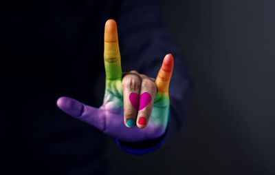 Close-up of multi colored human hand over black background