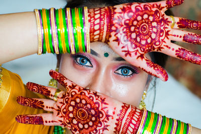 Portrait of mid adult woman with colorful bangles at home