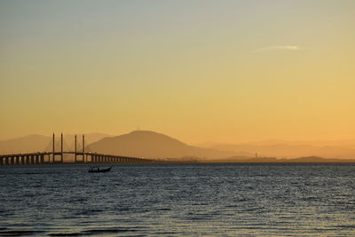 Pier on sea at sunset