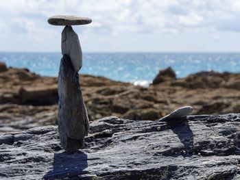 Balancing rocks on beach against sky