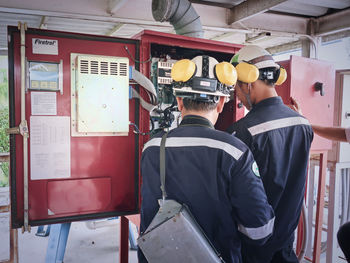 Rear view of men working at factory