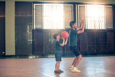 Father teaching son basketball