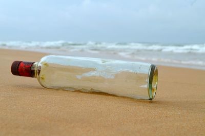 Close-up of bottle on beach
