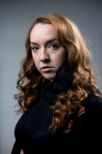Portrait of beautiful woman against gray background