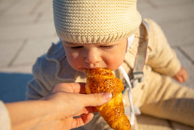 Close-up of boy eating croissant