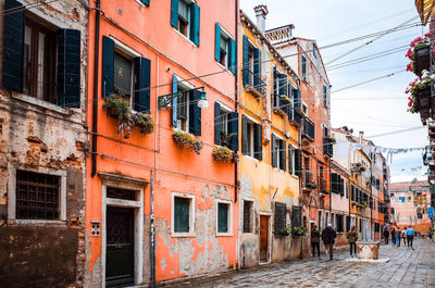 People walking on road along buildings