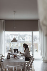 Woman sitting on table at home