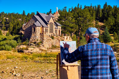 Rear view of man against built structure