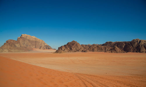 Scenic view of desert against clear blue sky