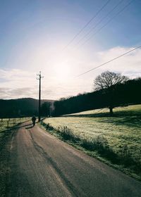 Road by field against sky