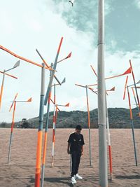 Rear view of man standing on land against sky