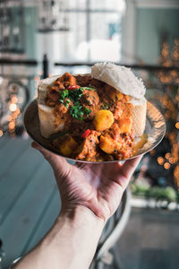 Close-up of hand holding food in plate