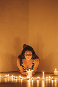 Portrait of woman sitting against wall