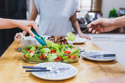 Group of friend eating fresh vegetable and fruit salad.