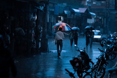 People walking on wet street in rainy season