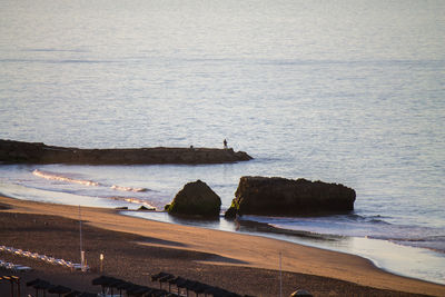 Distant view of man fishing in sea