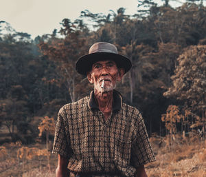 Portrait of man standing against trees