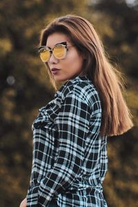 Portrait of young woman wearing sunglasses standing outdoors