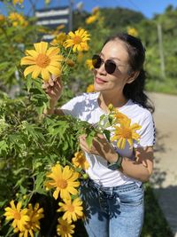 Portrait of young woman picking flowers