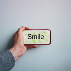 Cropped hand of person holding text against white background