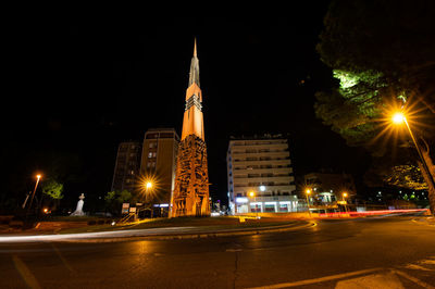 Illuminated buildings against sky at night