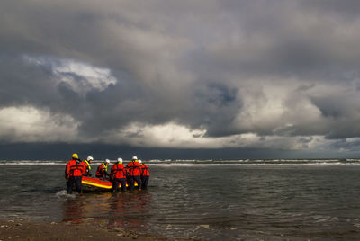 People at beach against sky