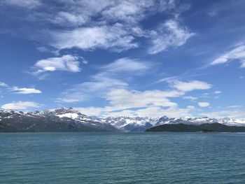 Scenic view of sea and snowcapped mountains against sky