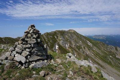 Stack of rocks on mountain against sky