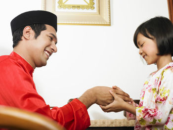 Father and daughter holding hands at home