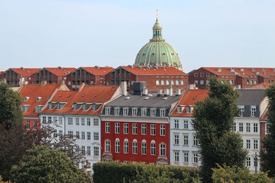 Buildings in city against clear sky