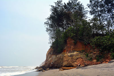 Rock formation on beach against sky