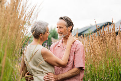 Side view of couple sitting on field