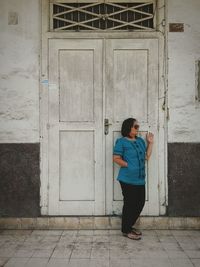 Full length of young man standing on door