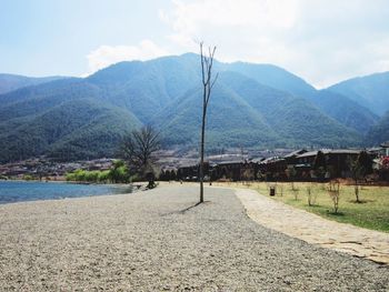 View of empty road along calm lake