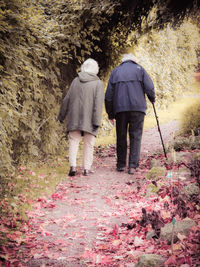 Rear view of people walking on footpath