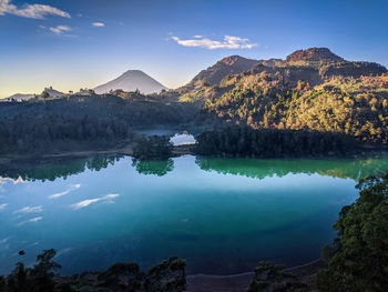 Scenic view of lake by mountains against sky