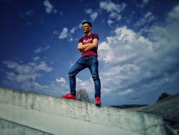 Full length of man standing on wall against sky