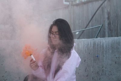 Woman holding smoke bomb at construction site