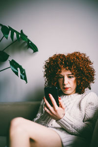 Woman using mobile phone at home