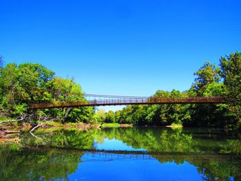 Bridge over lake against blue sky